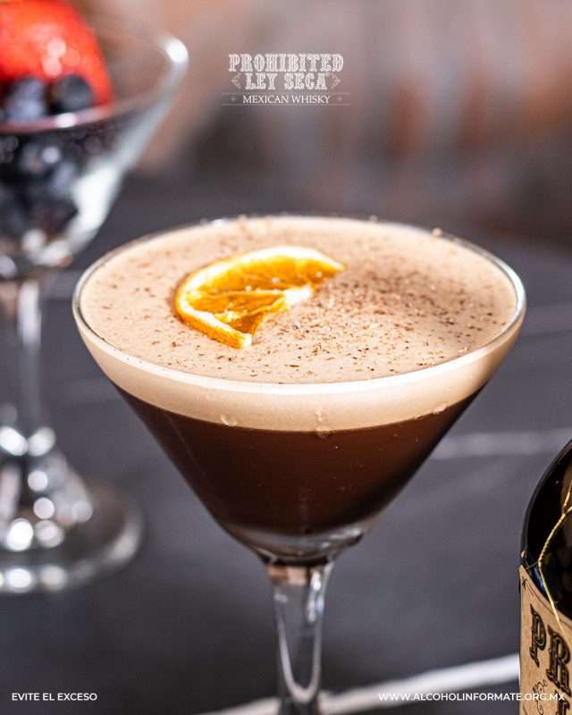 Coffee whisky cocktail served in a martini glass, featuring Ley Seca Mexican whisky, creamy foam, and a dried orange slice garnish.