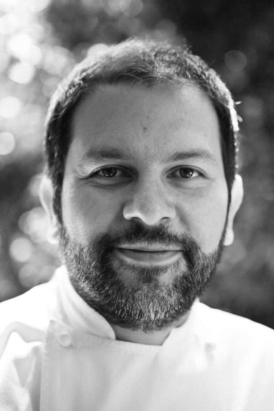 Chef Enrique Olvera con uniforme blanco en un restaurante moderno.